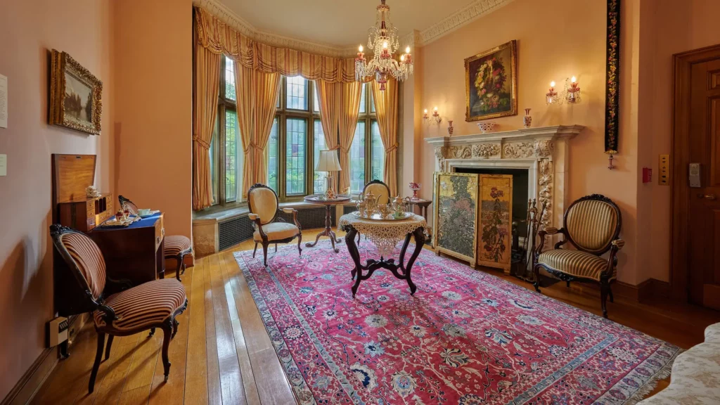 The Ladies Reception Room with rose-tinted walls, Bohemian glass fixtures, and French influences.