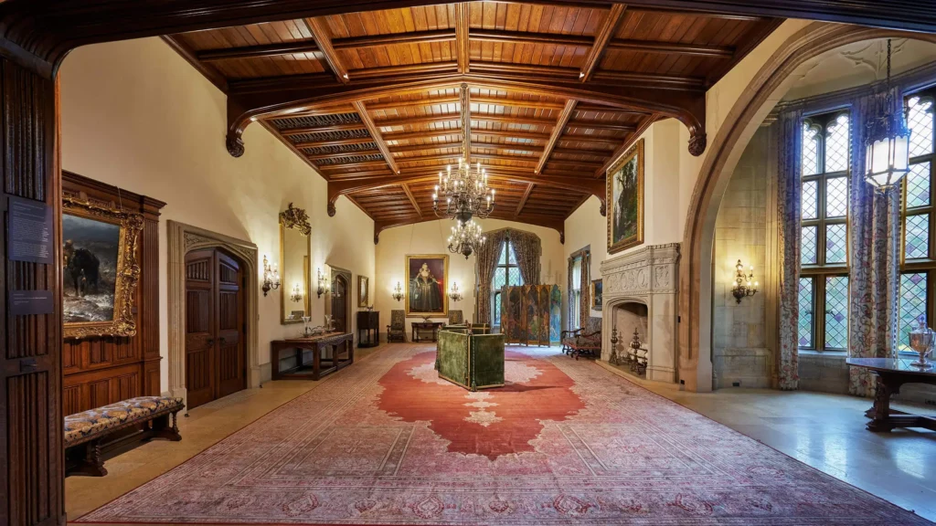 The Great Hall features an alcove on the right, large limestone fireplace, and 18-foot ceilings.
