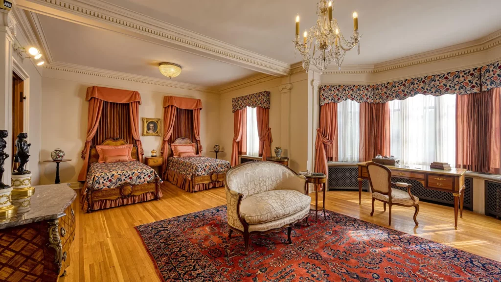 The Master Bedroom reflects an English Regency and French Empire styles, with two twin beds, mauve silk taffeta and antique French textiles.