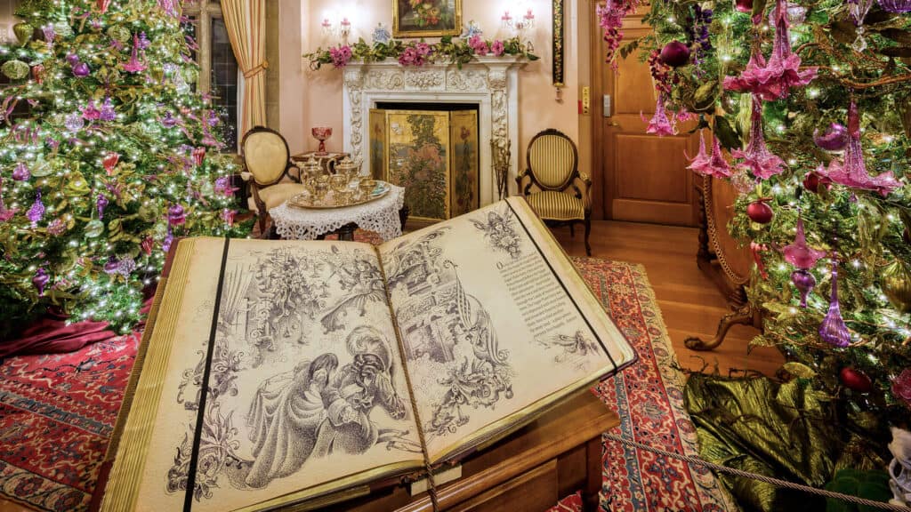 Two upside-down trees decorated in flowers and pink ornaments, and a large storybook.
