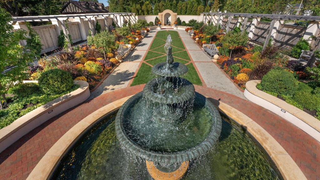 The Formal Garden fountain overlooking displays of orange, purple, and yellow flowers.