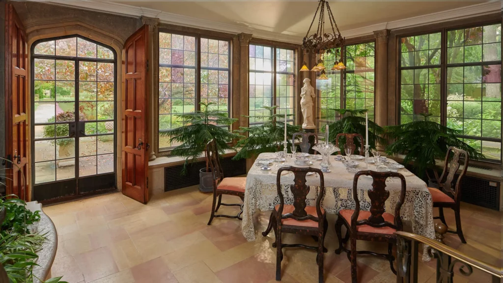 The Breakfast Room features a custom-made dining set and tinted glass panes in its many windows.