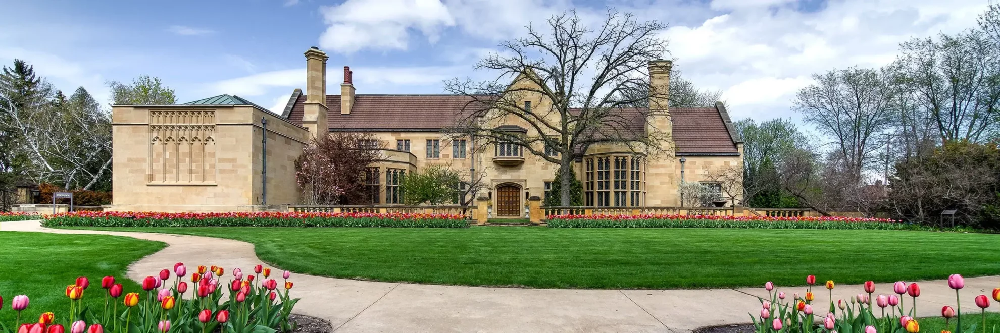 The front façade of the Paine mansion with colorful tulips in spring.