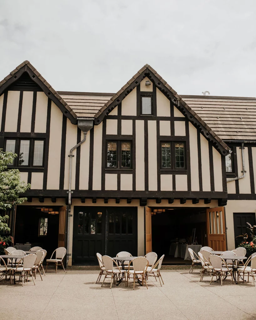 The Carriage House with its doors open to a patio with tables and chairs.