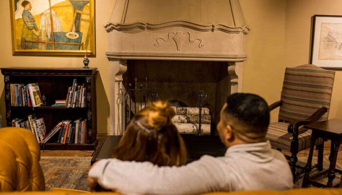 Two adults sit on a couch in the Studio.