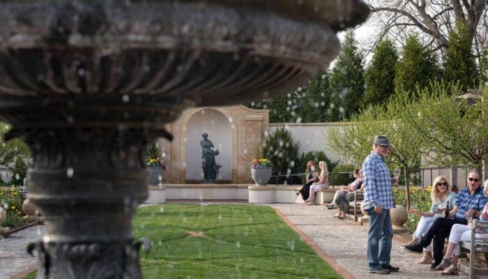 Groups of people converse in the Formal Garden.