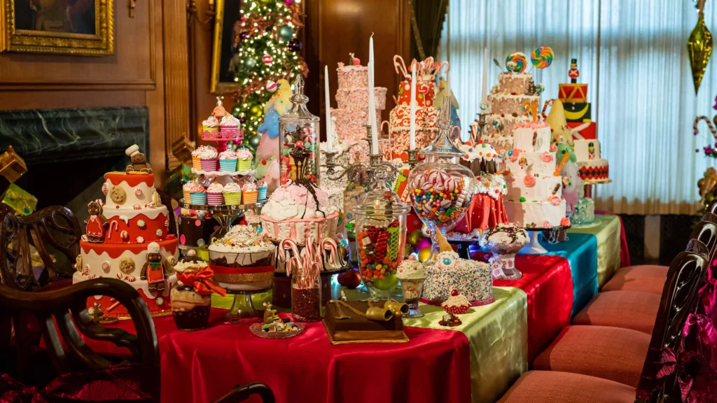 Four whimsical Christmas trees and a large table overflowing with colorful sweet treats.