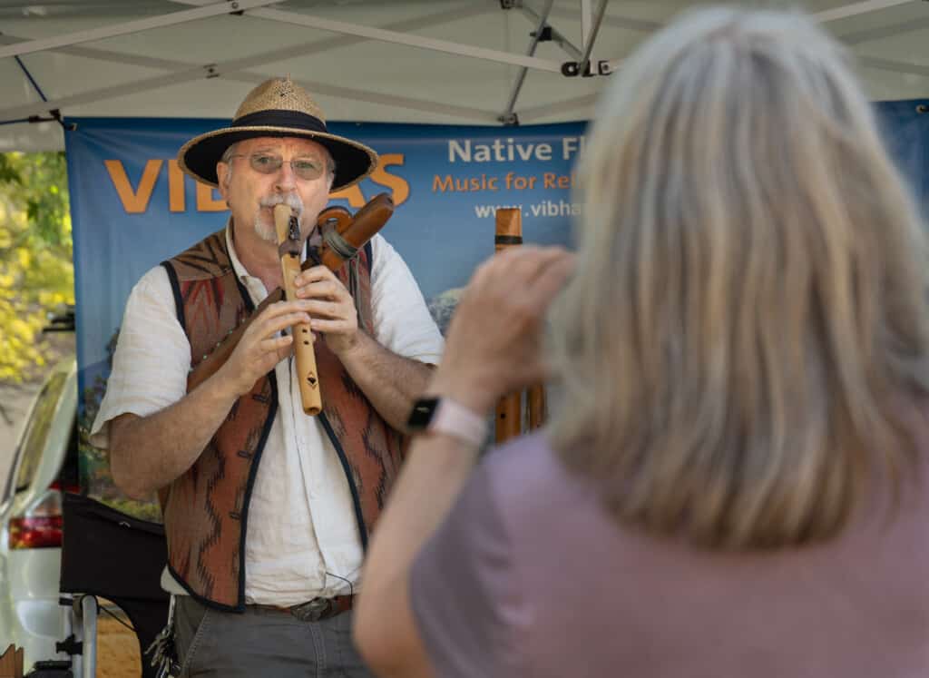 A man playing a wooden flute at Faire on the Green.