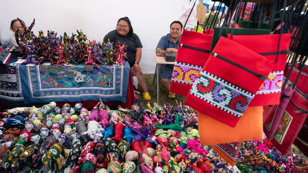 Hmong textiles and stuffed animals for sale at Faire on the Green in 2023.