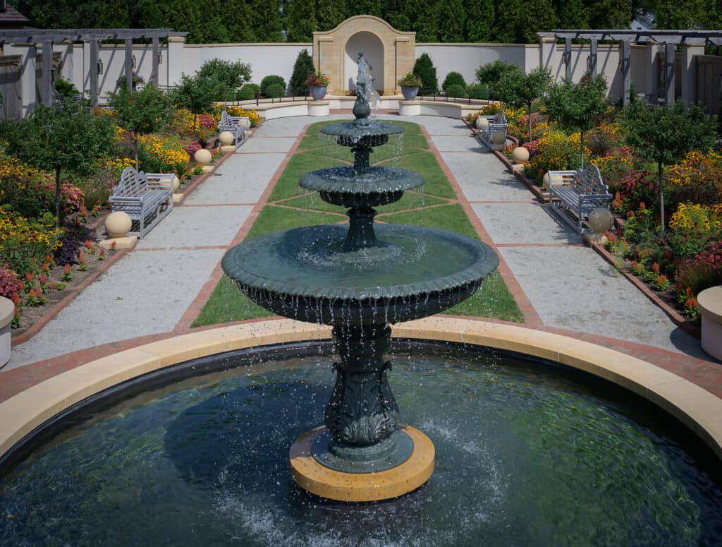 The Formal Garden water fountain overlooking garden beds in full bloom.