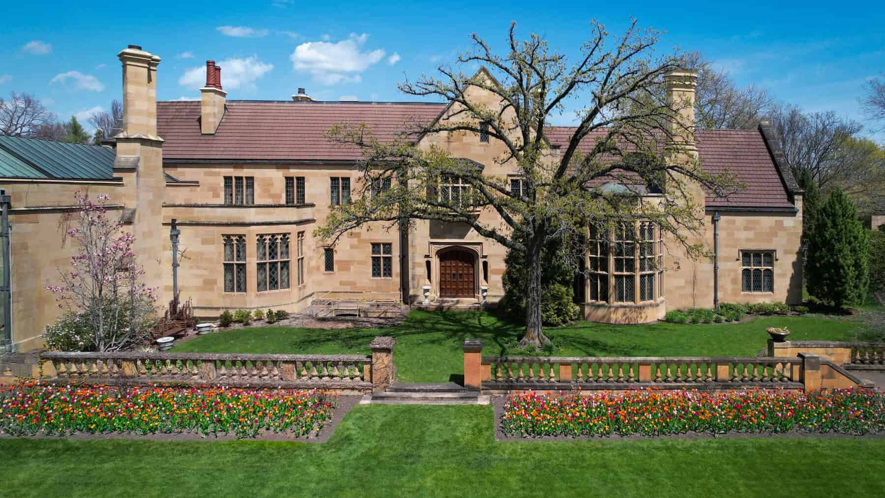 The front façade of the mansion with blooming tulips in spring.