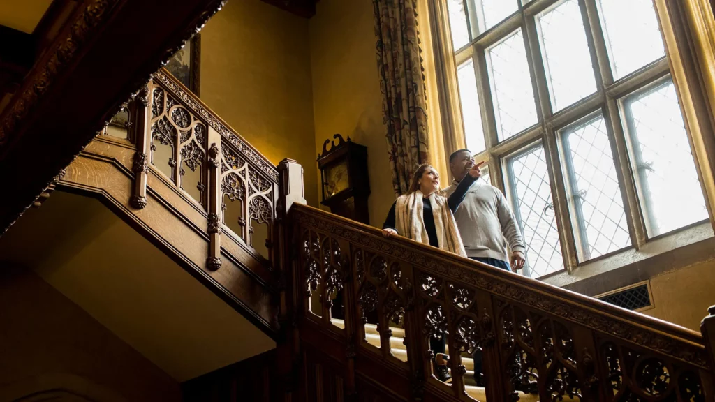 Two people stand on the grand staircase at the Paine.