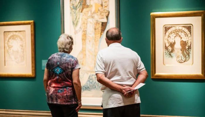 Two people view artworks in the Main Gallery.