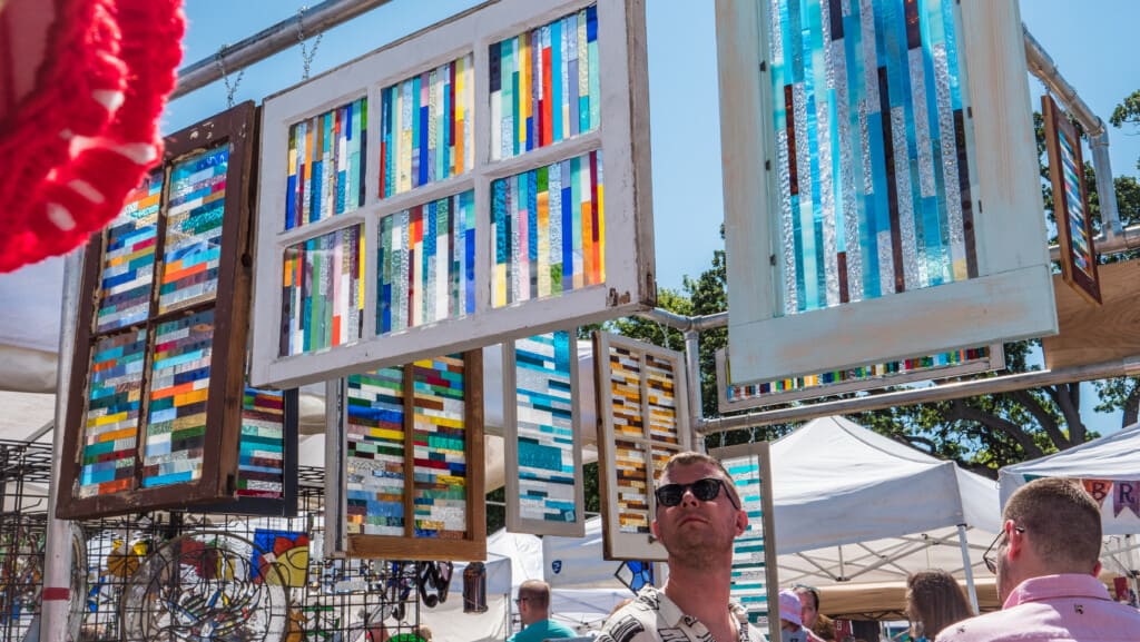 A man looks at stained glass windows at Faire on the Green.