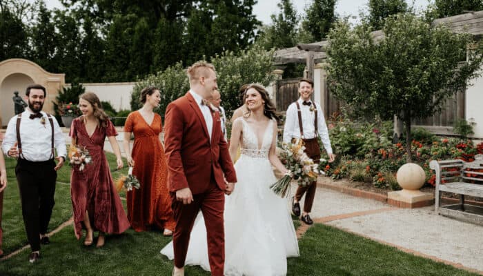 A couple walk with their bridal party in the Formal Garden.