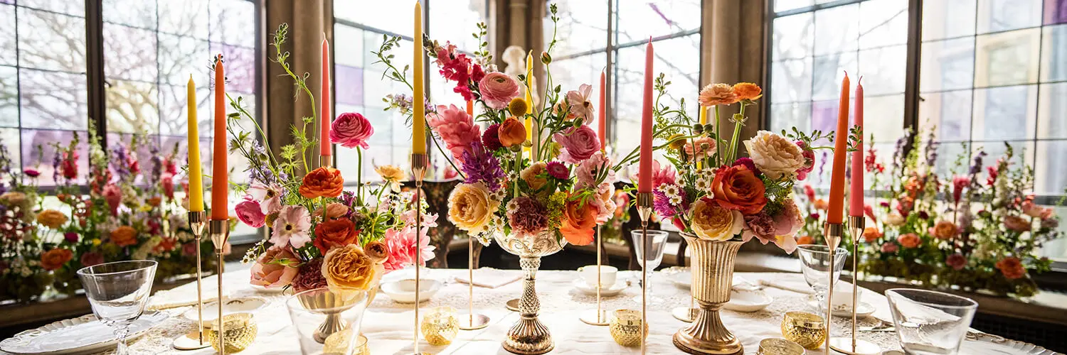 The Breakfast Rooms displays in bright pink and orange flower arrangements, with the sun shining in through stained-glass windows.