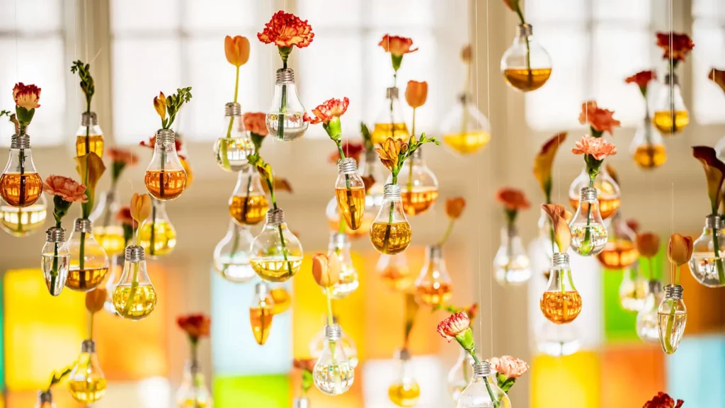 Individual flowers hang from the ceiling in the Conservatory in lightbulbs filled with orange and yellow hues of water.