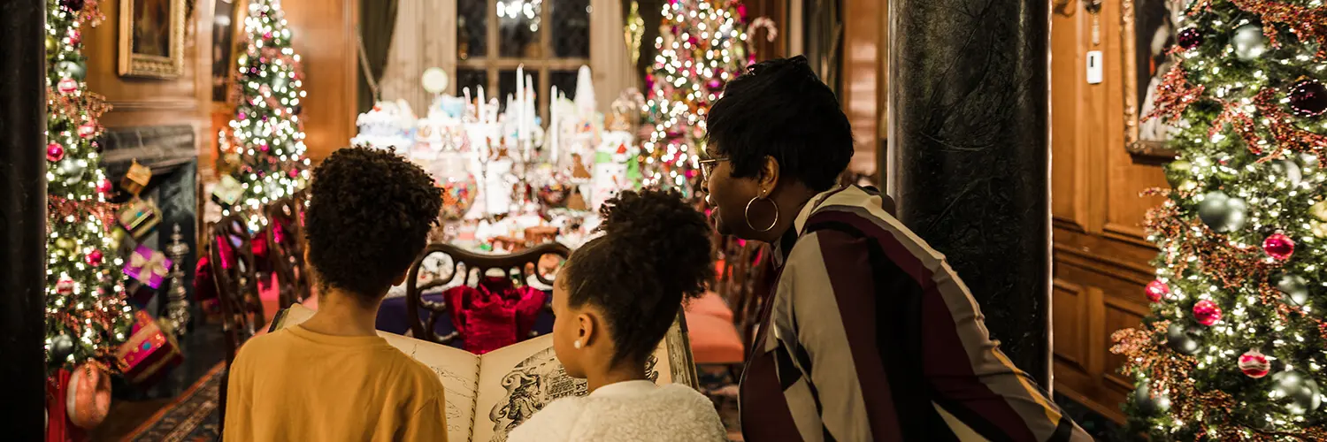 Two children read from Nutcracker storybook with their grandmother in the Land of Sweets.