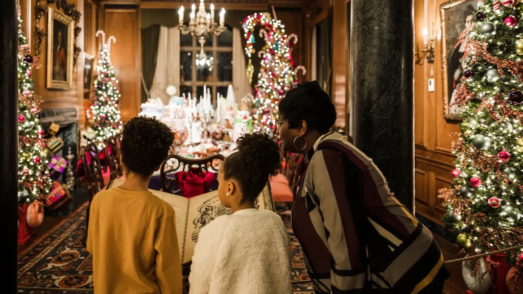 Two children read from Nutcracker storybook with their grandmother in the Land of Sweets.