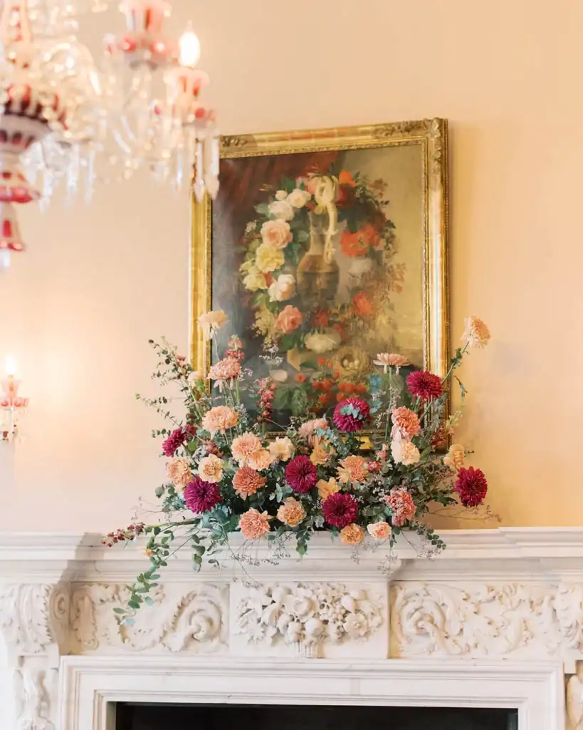 A floral arrangement above a fireplace.