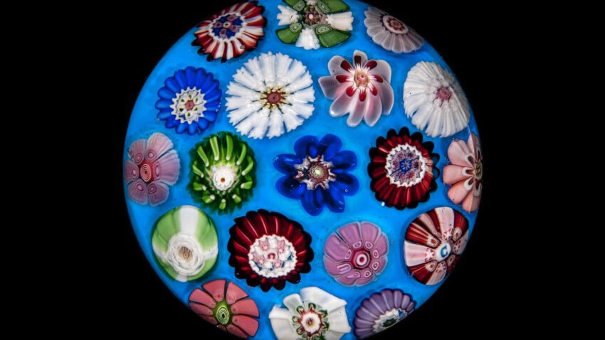 A blue paperweight featuring numerous different types of flowers.