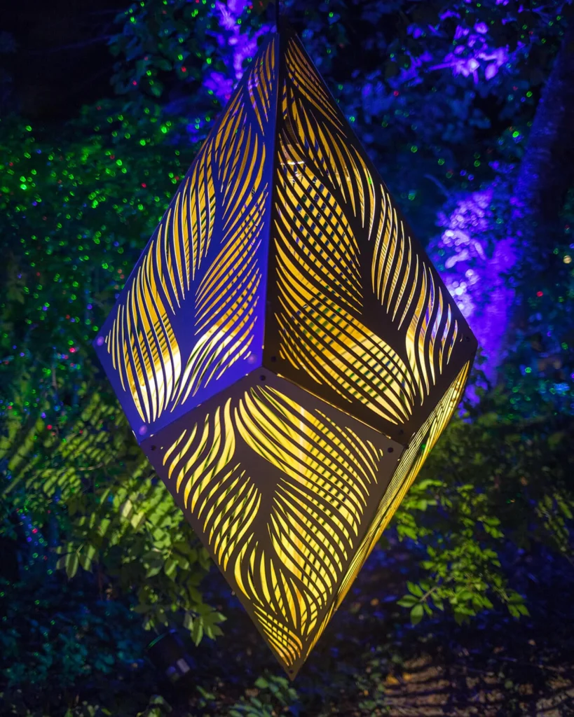 A geometric sculpture is illuminated at night.