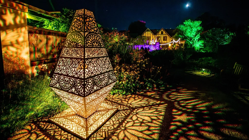An illuminated geometric sculpture at night.