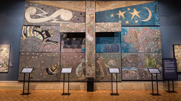 A multi-panel, large multicolor beaded artwork with a large cross at center titled “African Crucifixion.”