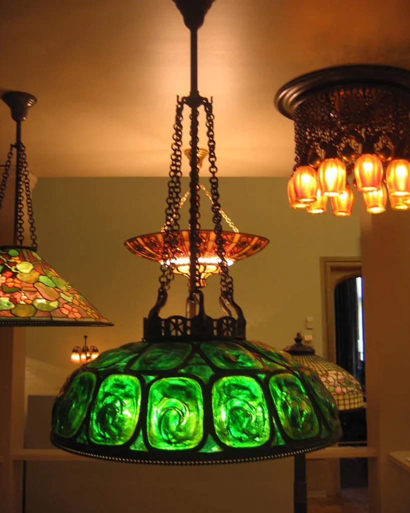 A variety of Tiffany chandeliers hang from a ceiling.