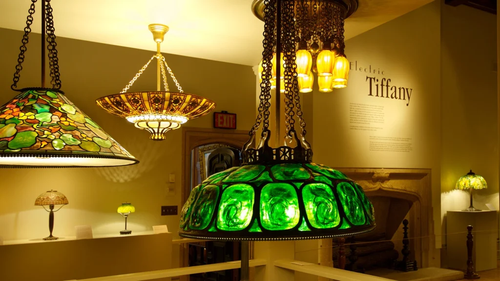 A variety of Tiffany chandeliers hang from a ceiling.