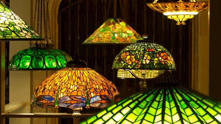 A variety of Tiffany lamps and chandeliers on display.
