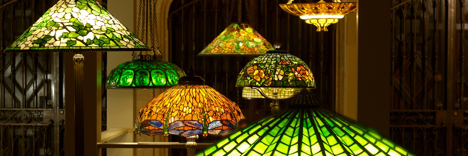 A variety of Tiffany lamps and chandeliers on display.