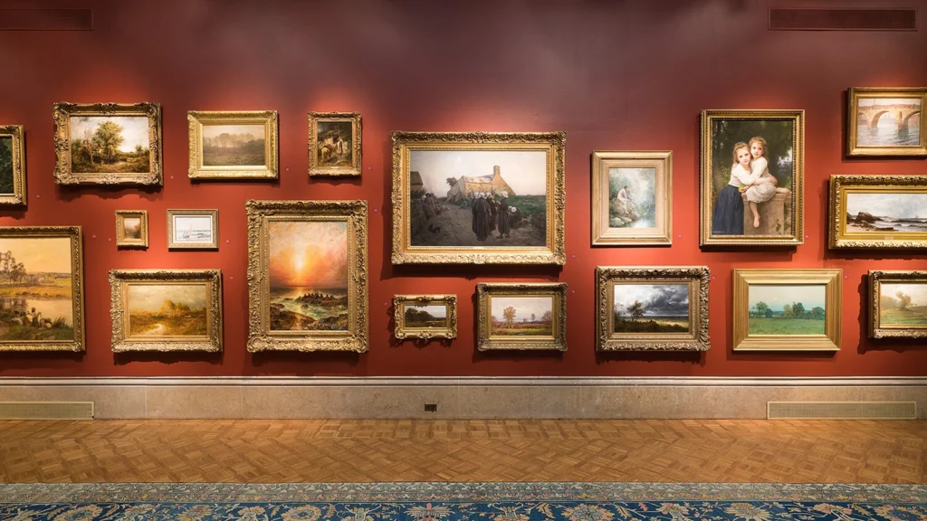 A view of the main gallery featuring a salon-style hanging of masterpiece artworks.