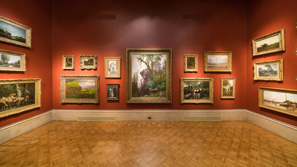 A view of the main gallery featuring a salon-style hanging of masterpiece artworks.