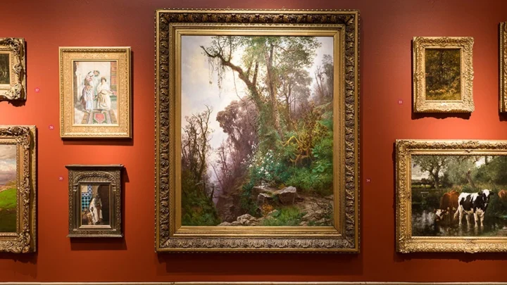 A view of the main gallery featuring a salon-style hanging of masterpiece artworks.