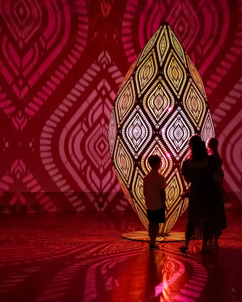 A family views an illuminated sculpture at The Nature of Light.