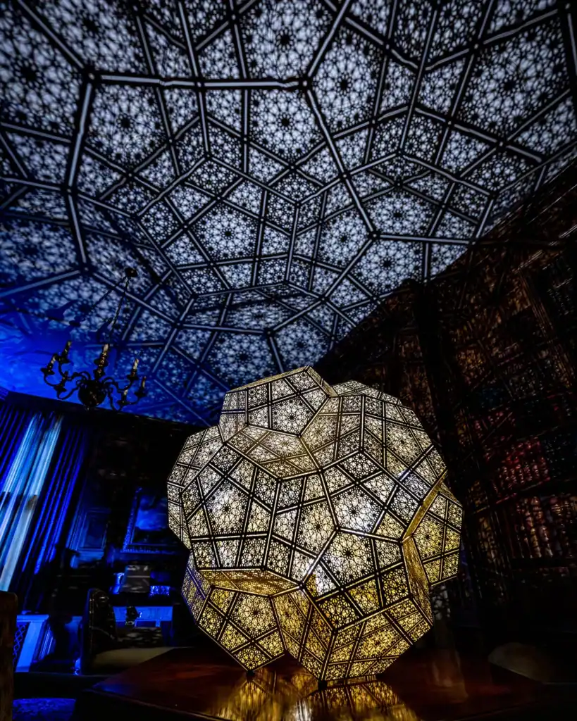 An illuminated sculpture in the Library of the Paine mansion at night.